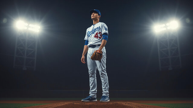 Baseball player stands on field at night