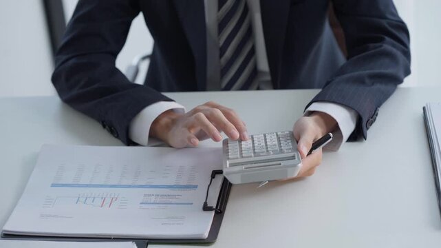 Asian businessman using calculator calculate fund for investment