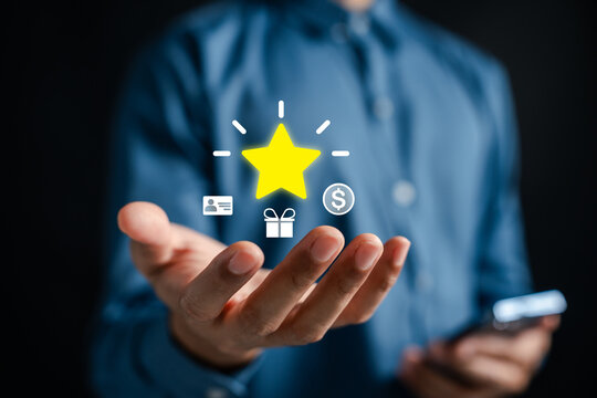 Loyalty points accumulation and rewards redemption system. Man holding digital glowing star, gift, and membership card icons for CRM marketing.