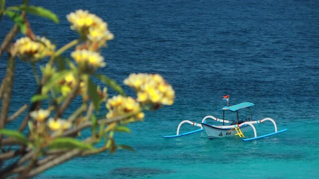 Traditional Balinese Snorkeling diving boat floating on vibrant ocean waves in Bali