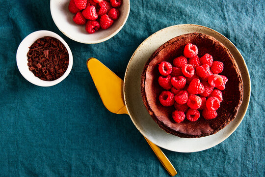 Chocolate Basque Cheesecake with Raspberries and Chocolate on Blue Linen Tablecloth Horizontal Shot
