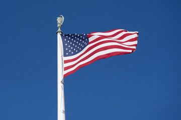 Flag American waving in blue horizon. American patriotic banner on liberty flag. USA democracy freedom symbol in flag. American independence culture on flag. © Volodymyr