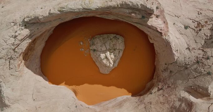 Cosmic Ashtray rock formation with orange sand pool inside eroded sandstone basin Utah desert, drone