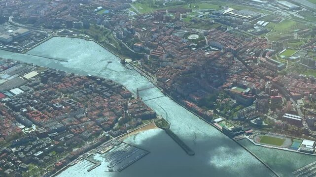 Elevated aerial view of Vizcaya bridge and La Ria of Bilbao, taken from an airplane cockpit flying at 3000m high over the harbor.