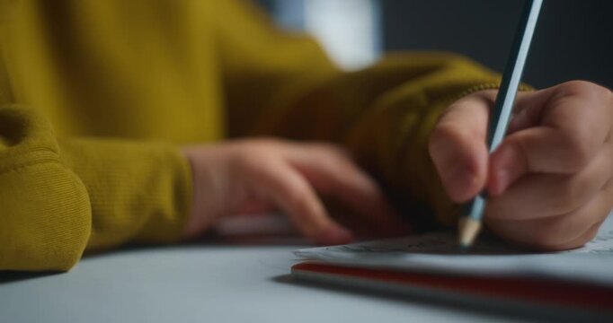 Young Boy Focuses On Neat Letter Formation. Student Concentrates On Precise Pen Strokes At Desk