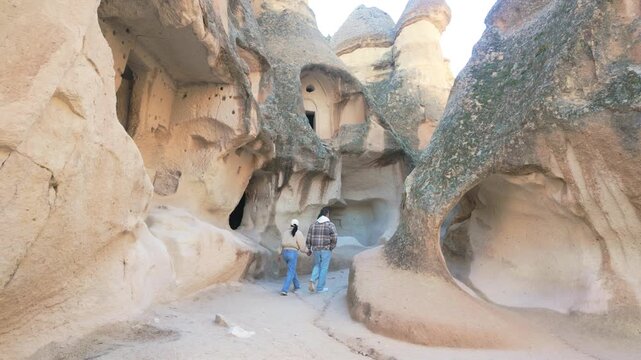 Witness the stunning landscapes of Cappadocia, Turkey as visitors stroll through its enchanting rock formations. Pasabag Monks Valley 
