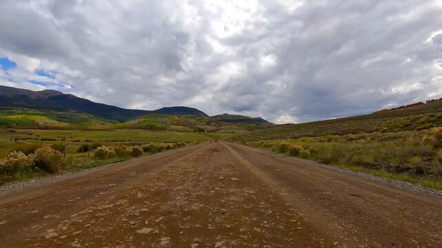 Driving POV on a bumpy dirt road in the Colorado countryside