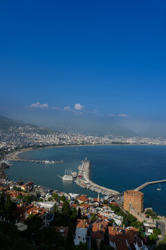 Panoramic aerial view of Alanya harbor with Red Tower and Seljuk Shipyard in Turkey. Scenic Mediterranean cityscape, historical fortress, ancient shipyard and Turkish Riviera travel concept