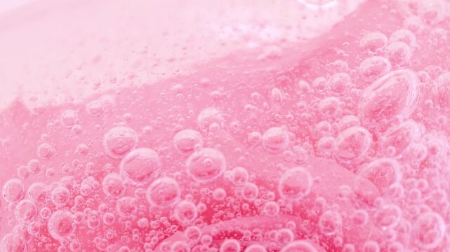 Serum gel texture on pink rose flower and bubbles, transparent cream background