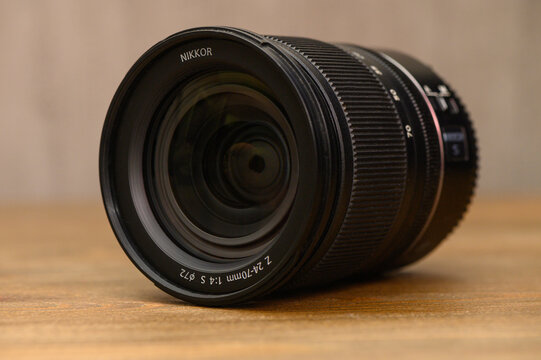 Nikon Z 24-70mm f4 S Lens on Wooden Table with Bokeh