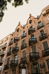 Fototapeta premium Close-up view of a stone building facade showing detailed ironwork balconies and window shutters.
