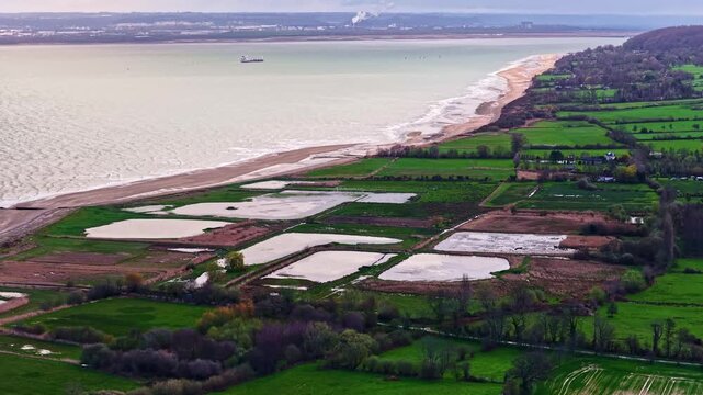 Drone shot of agricultural land with water-filled plots beside the French coastline - Plage de Pennedepie