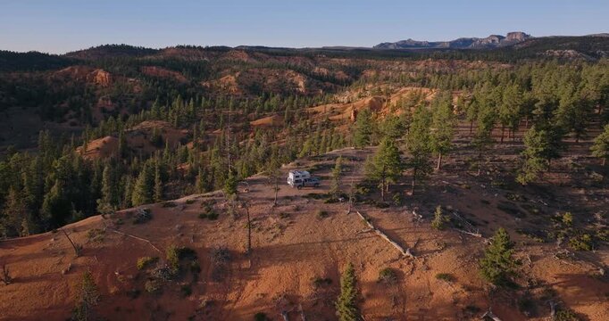 Wide aerial of pine forest and orange sandstone ridges across Dixie National Forest Utah plateau, drone overview