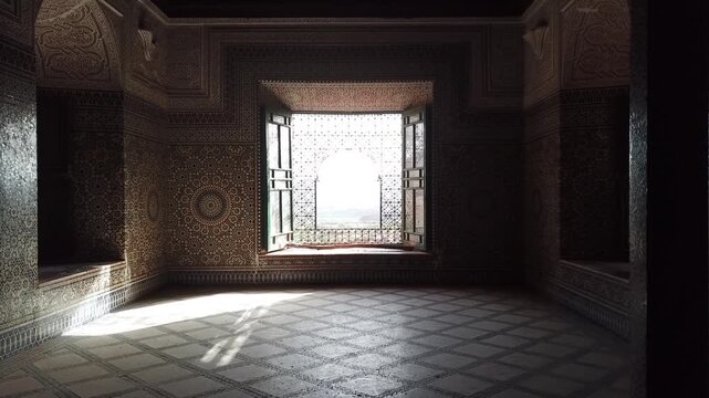 Interior view of a Moroccan room with a sunlit window, intricate zellige tiles, and geometric floor patterns. Natural light creates dramatic shadows, ideal for design and cultural visuals.