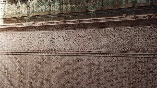 Close-up of intricate Moroccan wall patterns with carved plaster and zellige tile details. Rich geometric textures ideal for design, architecture, and cultural heritage visuals.