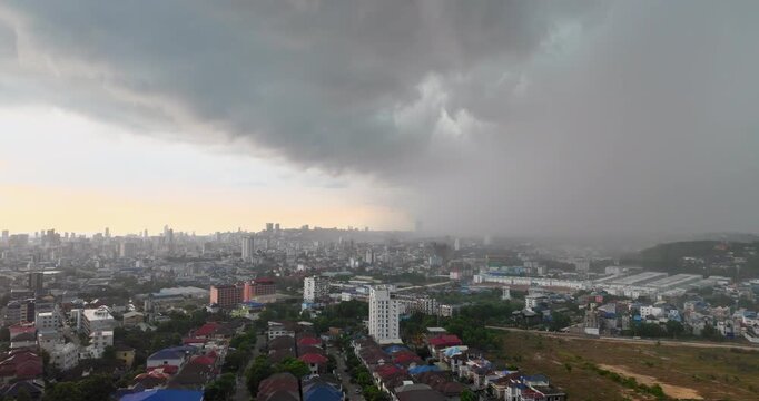 Heavy tropical rain curtain advancing over the Sihanoukville skyline, showing intense precipitation and reduced visibility