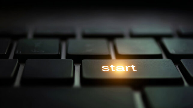Start button illuminating on a dark keyboard, symbolizing new projects, initiatives, or the beginning of technological processes