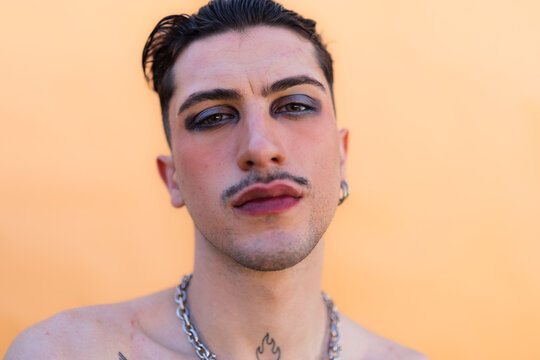 Young man expressing unique style with bold makeup