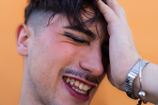 Young person smiling with makeup and tooth gem