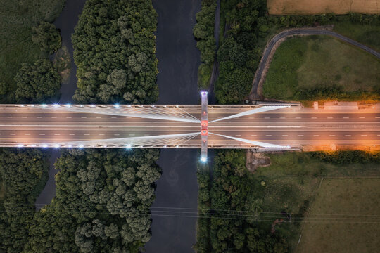 Aerial view of the Mary McAleese Boyne Valley Bridge crossing the River Boyne surrounded by dense green forests and fields at dusk Drogheda, County Louth, Ireland.