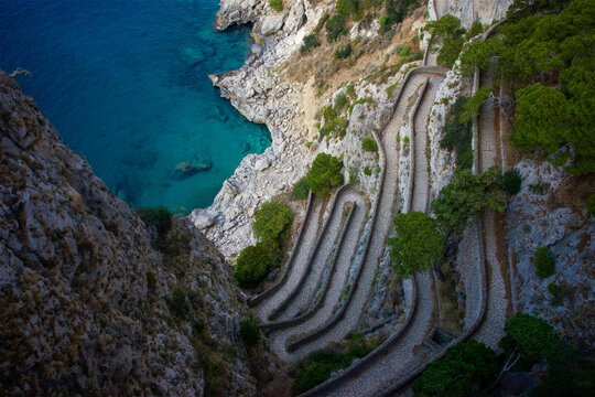 Aerial view of the winding stone path of Via Krupp carved into steep cliffs overlooking the turquoise Tyrrhenian Sea in Capri, Campania, Italy.