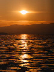 Obraz premium Golden sunset over frozen Lake Baika with Buchanka on horizon in Siberia 