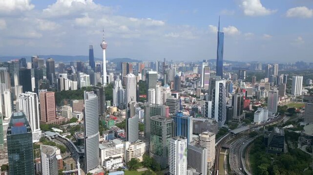 Aerial drone view of Kuala Lumpur featuring iconic observation tower and modern skyscrapers. Wide urban skyline showing city development and architecture in Malaysia.