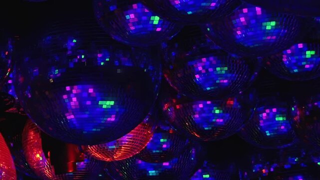 A dazzling disco environment glows with countless mirror balls reflecting vibrant green, purple, and red light. Guests revel in a joyous birthday celebration, dancing into the night.
