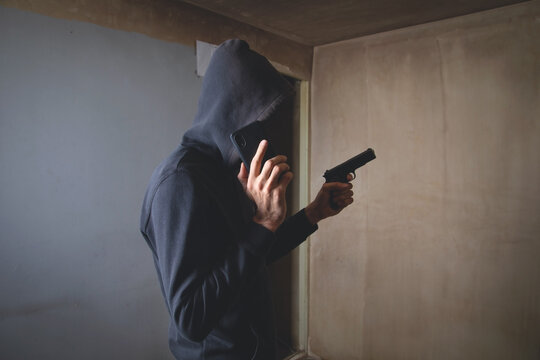 Man with a gun in the dark room.
