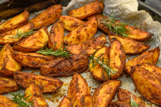 Herb-Roasted Potato Wedges with Rosemary on Wooden Surface