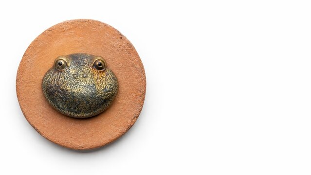 Highly stylized pebble shaped ceramic frog figurine without protruding limbs