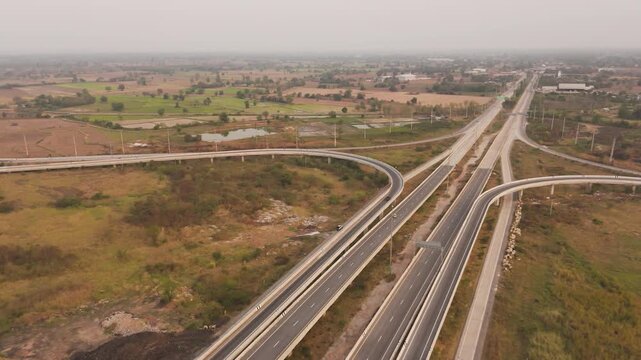 Drone footage scenic landscape of the traffic at bridge over the intersection in the rural place 