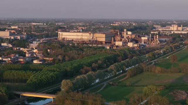 Acciaieria Arvedi steel plant in Spinadesco Cremona Lombardy Italy beside irrigation canal within Po Valley industrial district and agricultural matrix with riparian vegetation and human altered lands