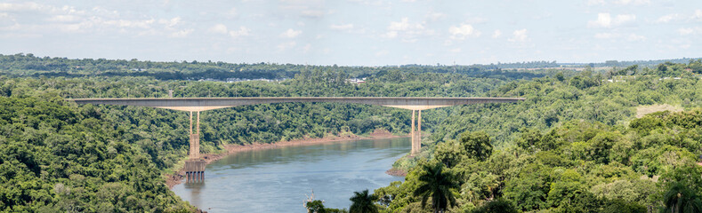 Obraz premium Tancredo Neves bridge to Brazil over river Iguazu in touristic town center, Puerto Iguazù, Argentina