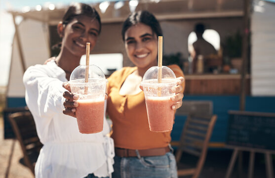 Portrait, women and happy with smoothie outdoor by food truck for wellness, bonding or weekend break. Friends, smile and cups for diet, healthy drink or beverage as small business customer or support