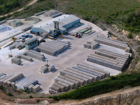 Aerial view of the Marshalls Maltby industrial site featuring large warehouses and organized stacks of concrete blocks near a quarry in Maltby, England, United Kingdom.