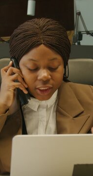 Individual calmly reviewing papers during phone conversation