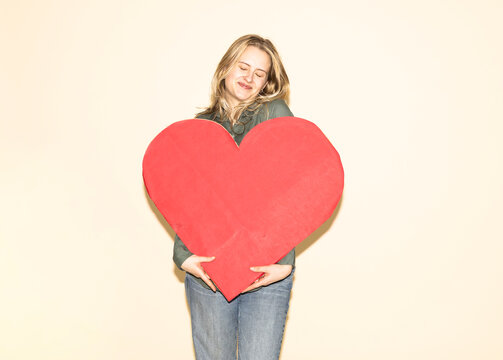 Female customer embracing a red paper heart showing brand loyalty