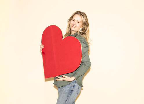 Woman holding a red paper heart showing brand loyalty