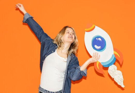 Female entrepreneur holding handmade paper rocket celebrating success