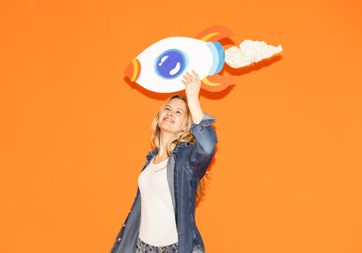 Woman holding a handmade paper rocket to symbolize success and growth