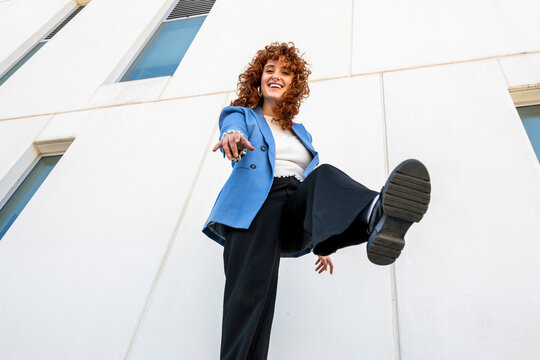 Smiling entrepreneur pointing at camera outdoors in Spain