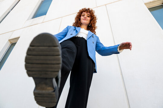 Low angle view of confident businesswoman stepping forward outdoors