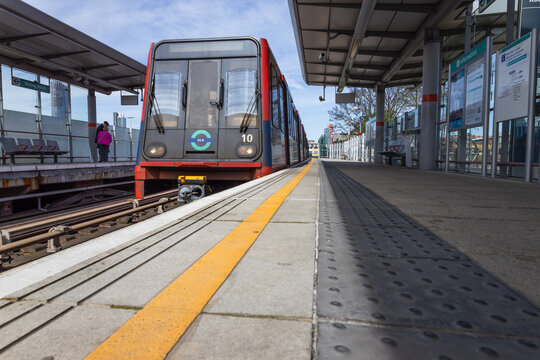 DLR train arriving at a London station platform. London, UK, 14 April 2024