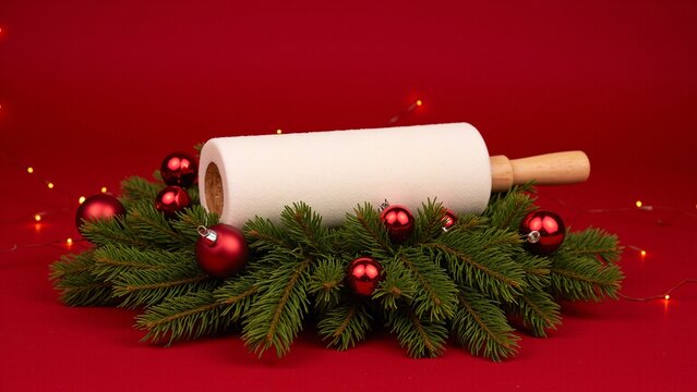 A festive Christmas tree adorned with red ornaments and a roll of christmas wrapping paper, ready for the seasonal celebration.