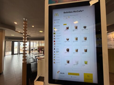 Palma, spain, may 2, 2026, mcdonalds mccafe menu displayed on a self service digital kiosk in a modern fast food restaurant with seating
