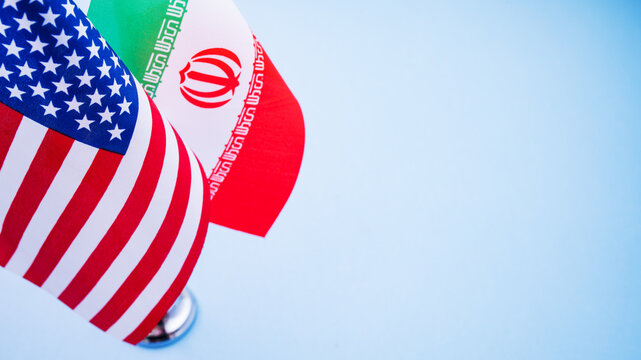 Flags of America and Iran close up isolated on background. Trade intensions between US and Iran concept.