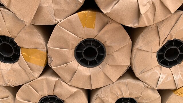 Close‑up view of paper roll ends showing folded kraft wrapping and black plastic cores