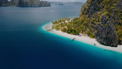 Fototapeta premium Stunning tropical island paradise, aerial view of a pristine white sand beach with turquoise water. Idyllic vacation destination, a serene coastal landscape for travel and tourism.