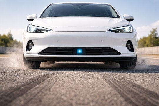 Sleek white car with blue lights leaving tire marks on road